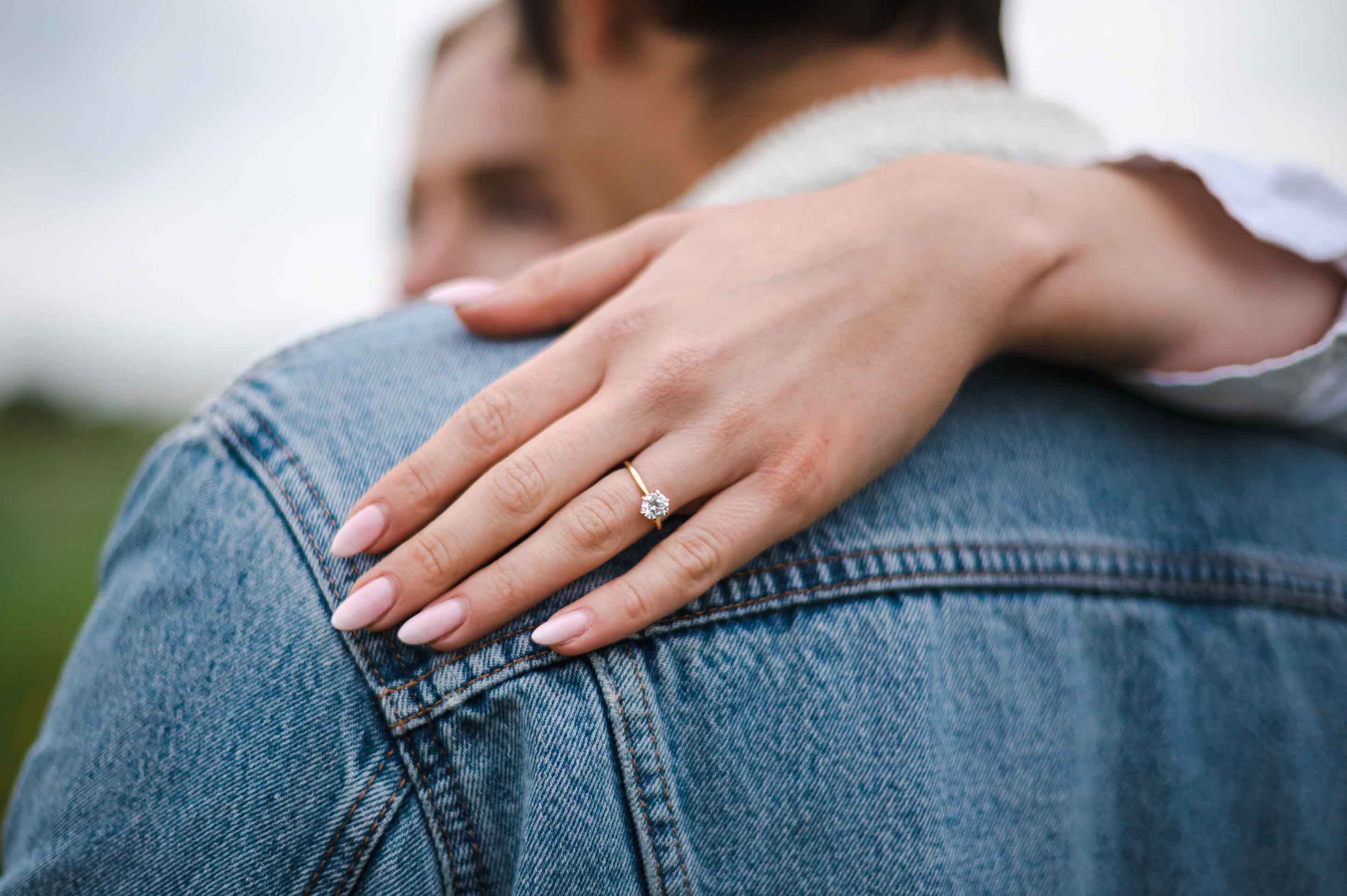 A young woman's hand with pink nails done by Private Beach Salon.
